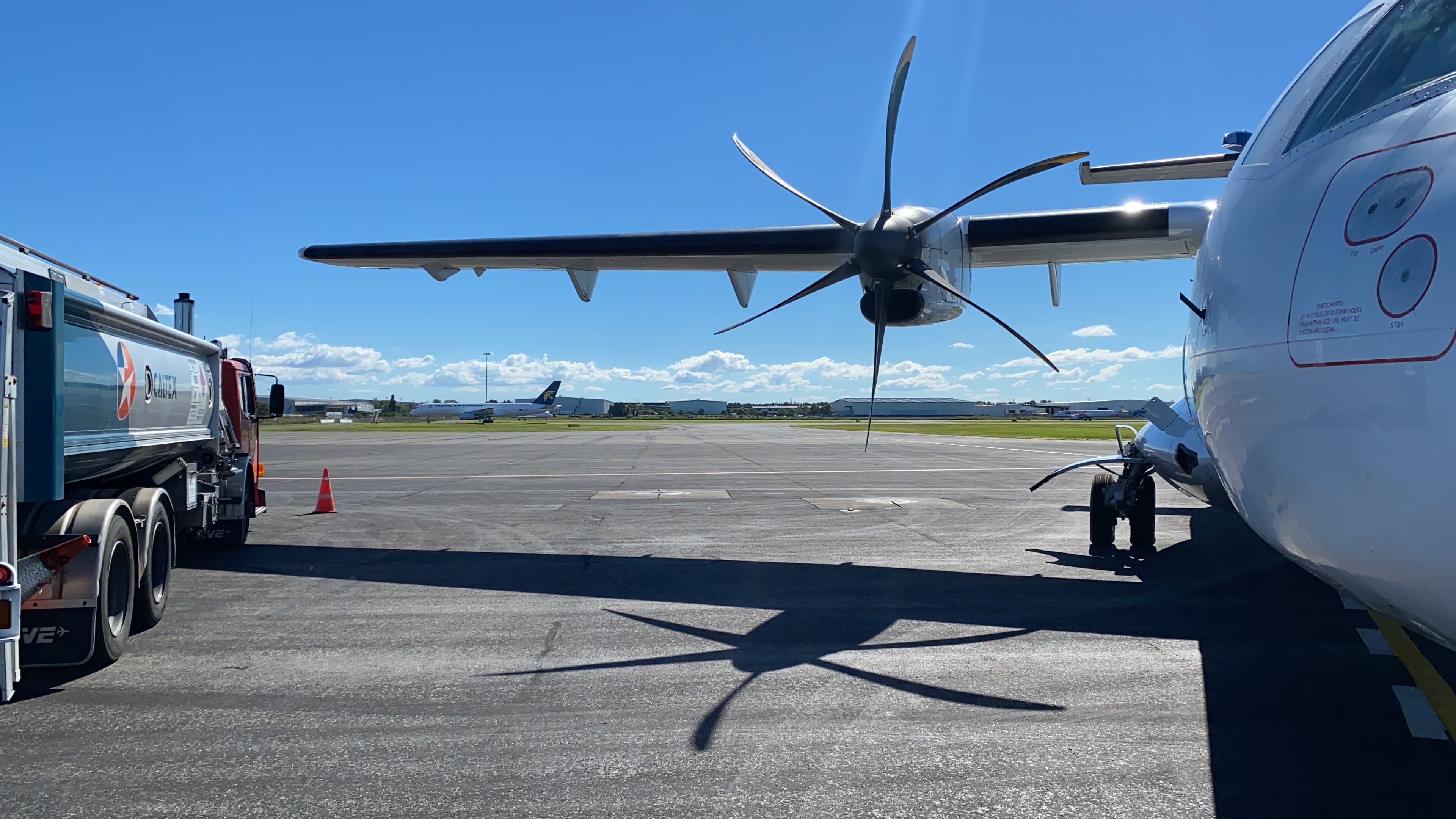 ATR aircraft being refueled on the ramp at dusk