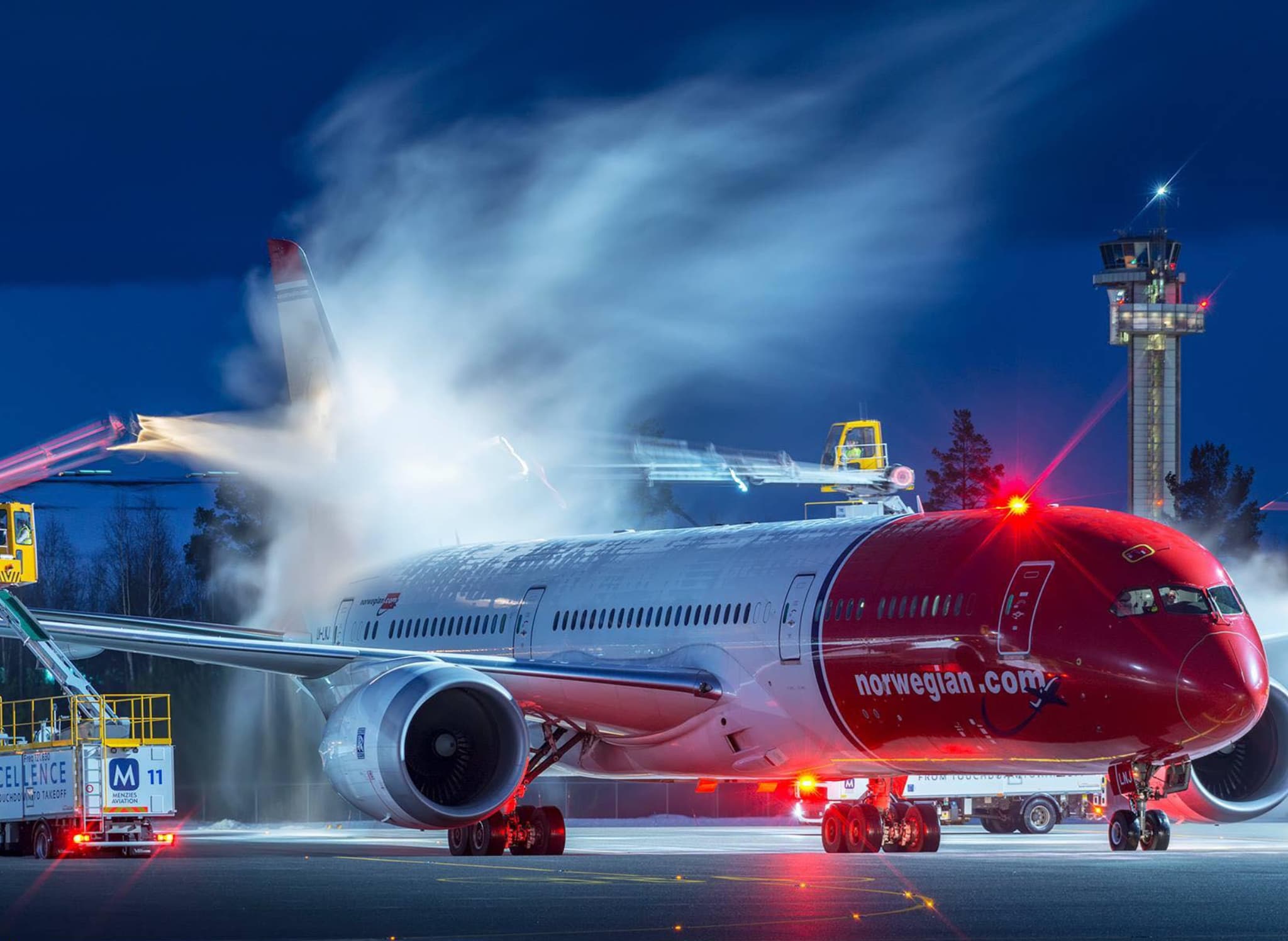 Norwegian Dreamliner undergoing deicing on a winter morning